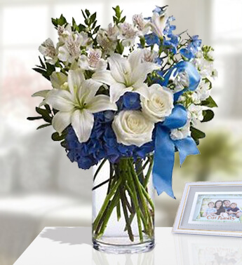 1 stem of White lilies ,6 stem of White Rose,with 3 stem of White Astromeria, Blue Hydrangea & blue ribbons in a Glass vase (one sided Round arrangement) Blissful Bouquet
