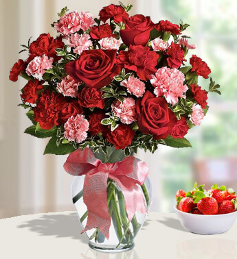 30 red and pink carnations and 6 red roses in a Glass Vase (one sided round arrangement) Charming Choices